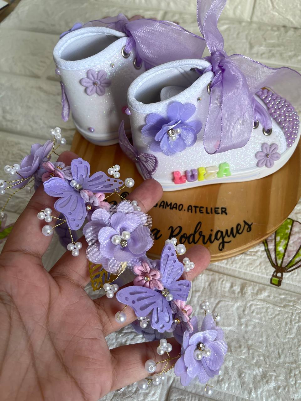 Bebê com sapatinhos lilás de borboletas